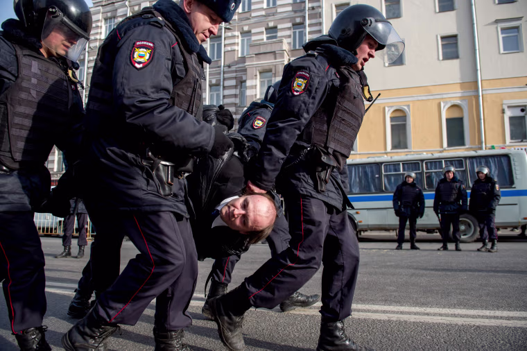 Image: Police officers detain a man during an unauthorized anti-corruption rally in central Moscow.