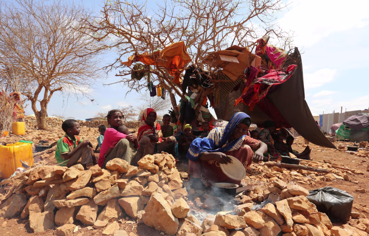 Image: An internally displaced Somali woman prepares a meal outside her shelter after fleeing from drought stricken regions in Baidoa, March 26.