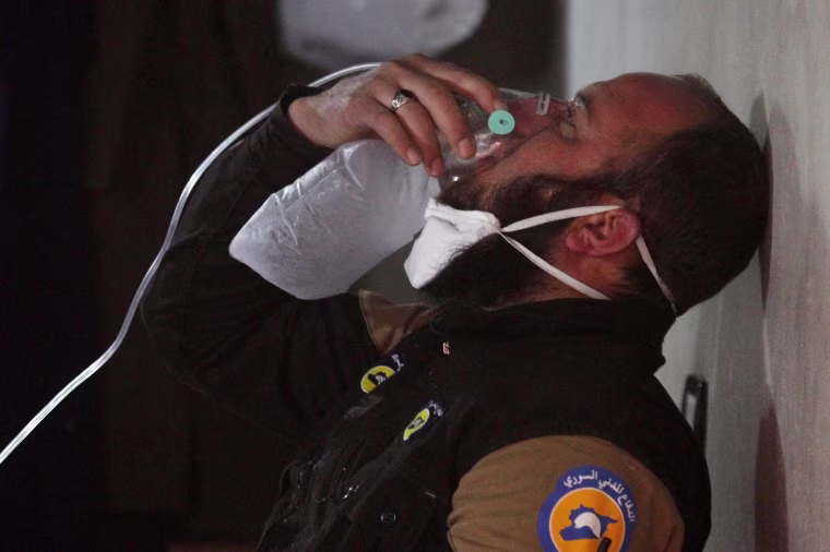 Image: A civil defense member breathes through an oxygen mask, after what rescue workers described as a suspected gas attack in the town of Khan Sheikhoun in rebel-held Idlib