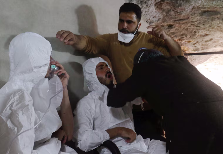 Image: A man breathes through an oxygen mask as another one receives treatments, after what rescue workers described as a suspected gas attack in the town of Khan Sheikhoun in rebel-held Idlib