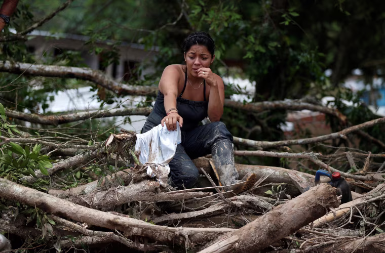 Image: A woman is seen on a destroyed street after flooding and mudslides caused by heavy rains in Mocoa