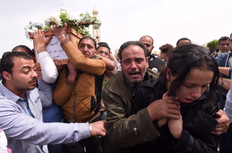Image: Family members carry the coffin of a victim from Alexandria during a funeral procession at the Monastery of Marmina in the city of Borg El-Arab, April 10.