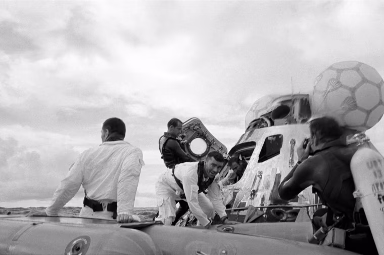 S70-35610 (17 April 1970) --- A water level view of the Apollo 13 recovery operations in the South Pacific Ocean. The three astronauts as seen egressing their spacecraft. John L. Swigert Jr. (back to camera), command module pilot, is already in the life raft. Fred W. Haise Jr., lunar module pilot, facing camera, is stepping into the life raft. James A. Lovell Jr., commander, is leaving the spacecraft in the background. A United States Navy underwater demolition team assists with the recovery operations. The three crewmembers were picked up by helicopter and flown to the prime recovery ship, USS Iwo Jima. The Apollo 13 Command Module (CM) splashed down at 12:07:44 p.m. (CST), April 17, 1970, to conclude safely a perilous space flight. Though the Apollo lunar landing mission was canceled, a disastrous loss of three astronauts was averted.