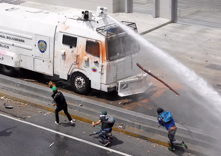 Image: Police water cannon disperses demonstrators during a protest in Venezuela