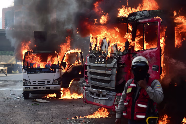 Image: Trucks burn in flames during a demonstration in Caracas