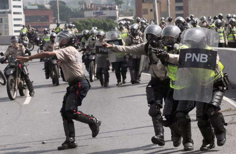 Image: Police officers walk towards anti-government protesters