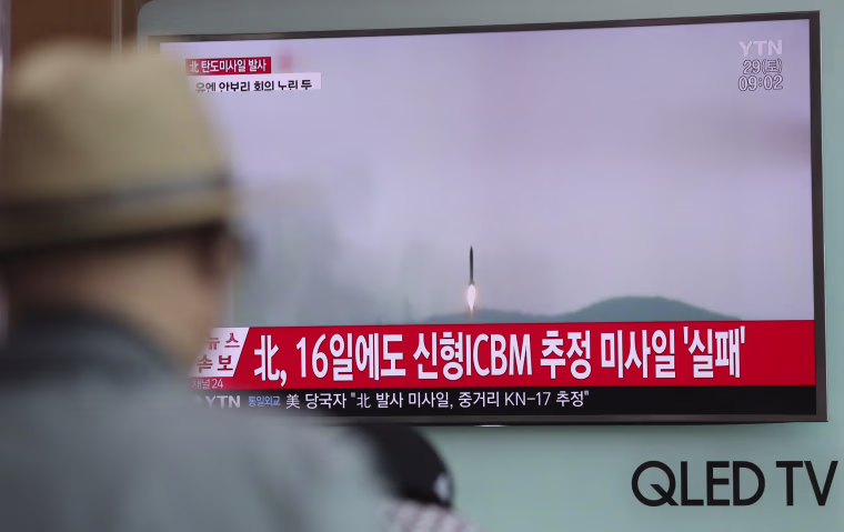 Image: A man watches a TV news program reporting about North Korea's missile firing with a file footage in Seoul.