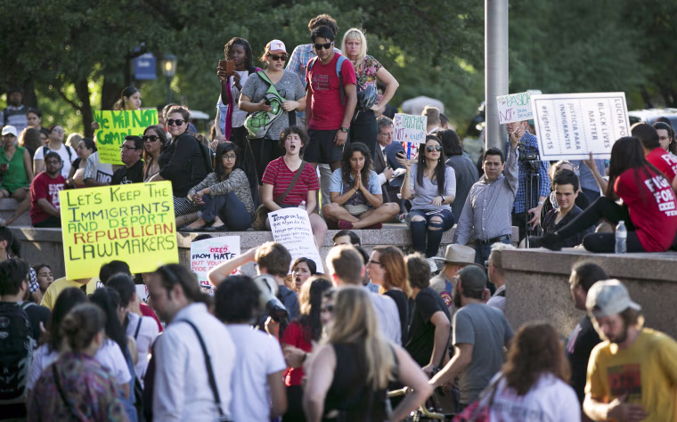 Image: Protesters, who are against the Senate Bill 4 Sanctuary Cities ban, rally outside the Texas Department of Insurance building