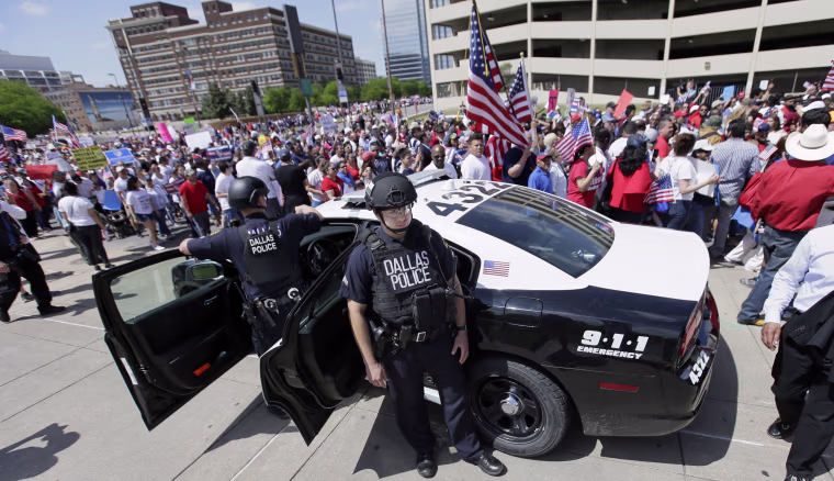 Dallas police stand guard during a march through downtown Dallas on April 9 to call for an overhaul of the nation's immigration system and end to what organizers say is an aggressive deportation policy.