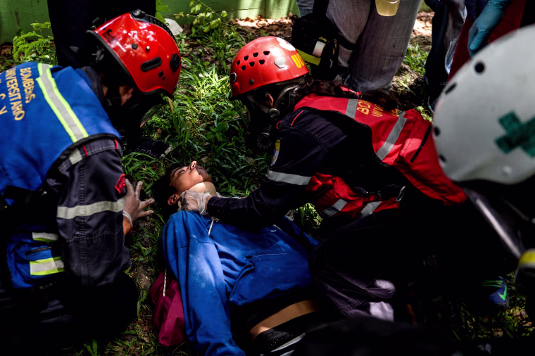 Image: An injured activist is assisted after clashes with riot police at the Central University of Venezuela in Caracas on May 4, 2017.