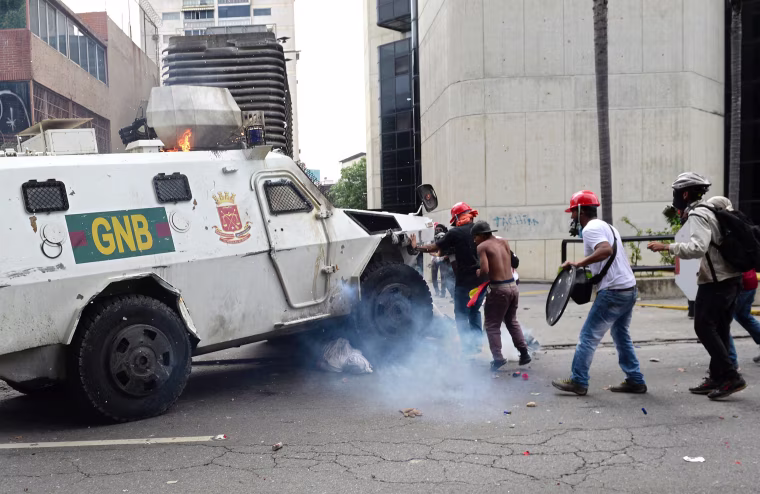Image: A Venezuelan National Guard riot control vehicle runs over an opposition demonstrator during a protest in Caracas on May 3, 2017.