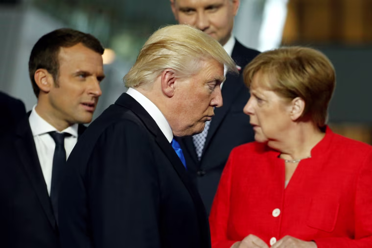 Image: President Donald Trump walks past French President Emmanuel Macron (L) and German Chancellor Angela Merkel on his way to his spot for a family photo during the NATO summit at their new headquarters in Brussels, Belgium, May 25, 2017.