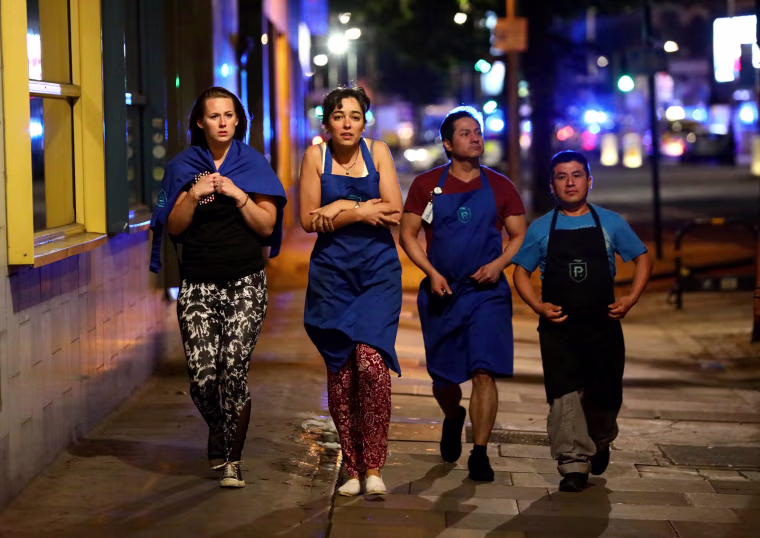 Image: Londoners leave the area following police orders, as they seal off the area for investigation.