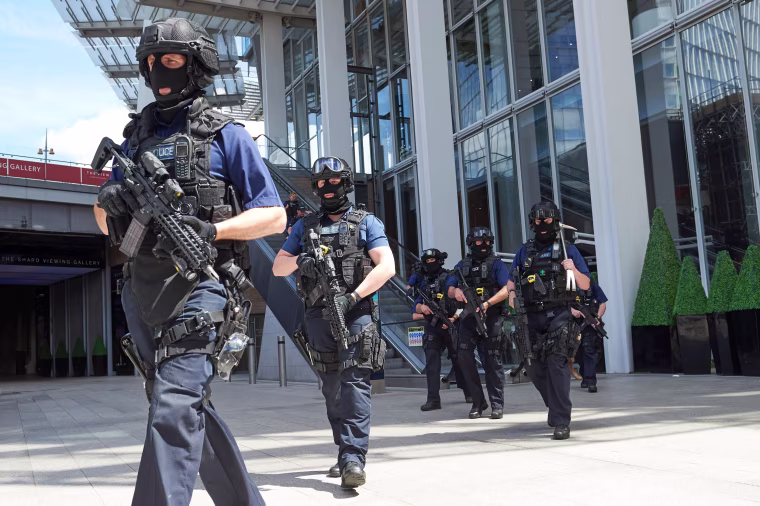 Image: Armed police officers patrol outside The Shard tower and London Bridge railway station.