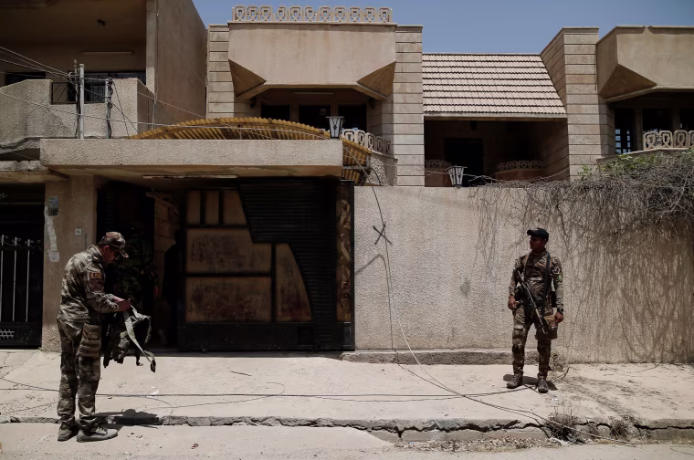 Image: Members of the Iraqi Army's 9th Armoured Division stand outside a compound used as a prison by Islamic State militants