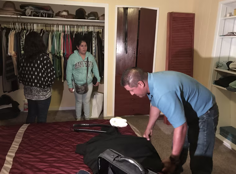 Image: Andres Magana Ortiz hugs packs his suitcase before turning himself into immigration officials