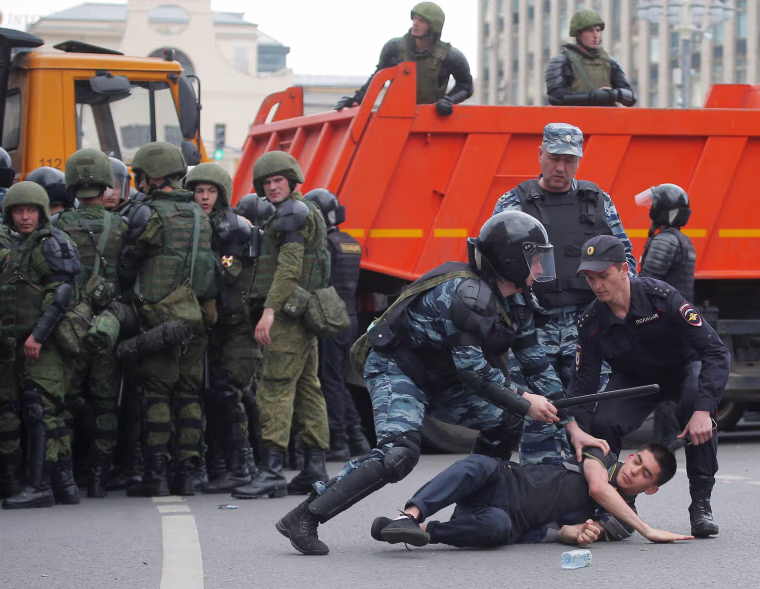 Image: Riot police detain a demonstrator during an anti-corruption protest in central Moscow