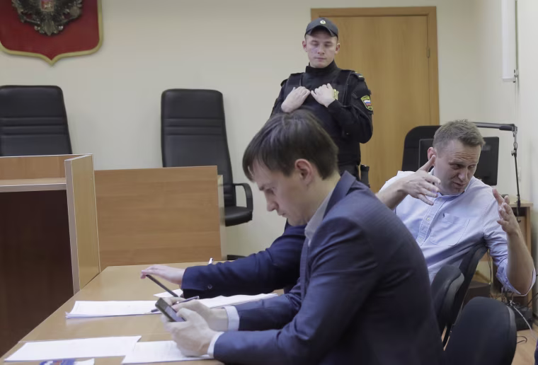 Image: Russian opposition leader Alexei Navalny, center, speaks before hearing in a court in Moscow