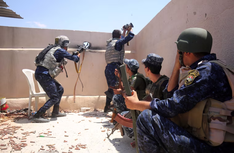 Image: Iraqi forces take a position on the roof of a building as they advance towards Mosul's Old City