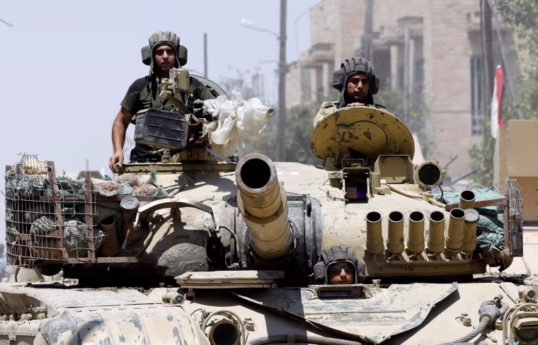 Image: Iraqi soldiers look out from a tank as they advances towards the Islamic State militants positions in the Old City in western Mosul
