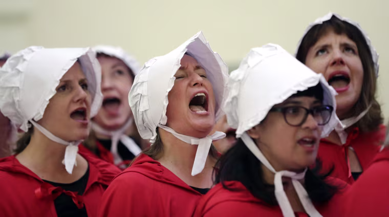 Image: Activists dressed as characters from The Handmaid's Tale chant in the Texas Capitol Rotunda
