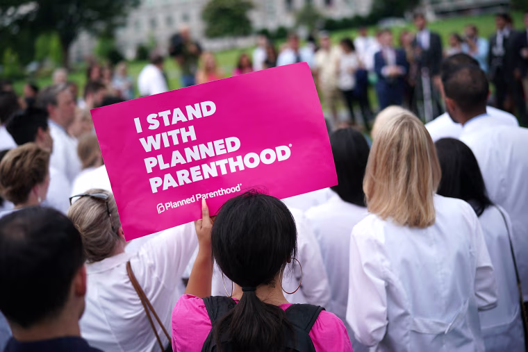 Image: A woman holds a sign as health care providers hold a news conference outside the U.S. Capitol