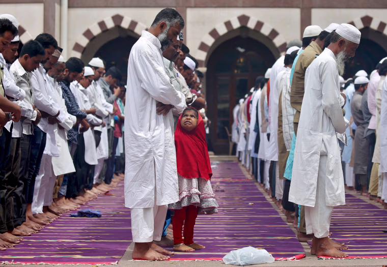 Image: A young Muslim girl reacts during Ramadan prayers