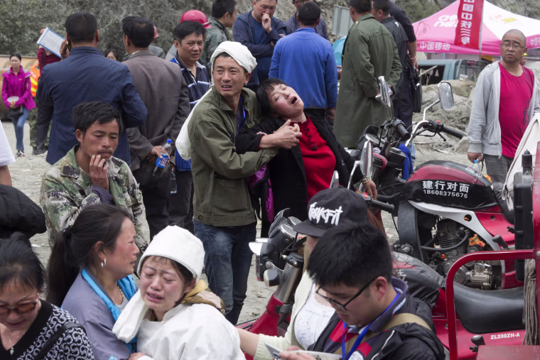 Image: Relatives grieve near the bodies of loved ones on June 25.