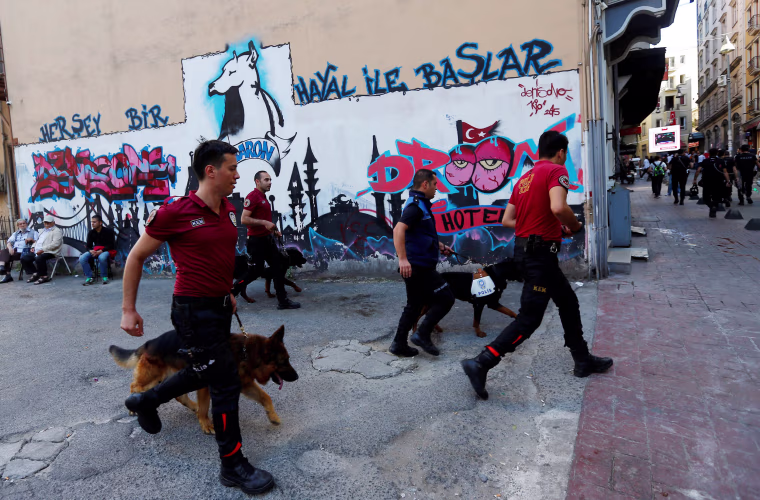 Image: Police officers with dogs chase LGBT rights activists as they try to gather for a pride parade in central Istanbul