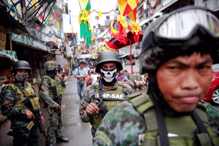 Image: Armed security forces take a part in a drug raid, in Manila