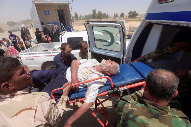Image: Iraqi soldiers carry a displaced man, who collapsed in exhaustion after fleeing from Mosul on June 29.