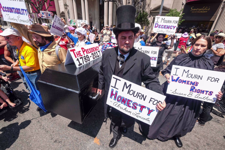 Image: Demonstrators carry a casket during an Impeachment March