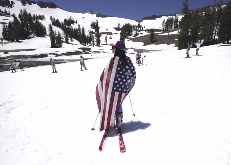 Image: Draped with an American flag, Kate Kunkel takes a break from skiing at Squaw Valley Ski Resort
