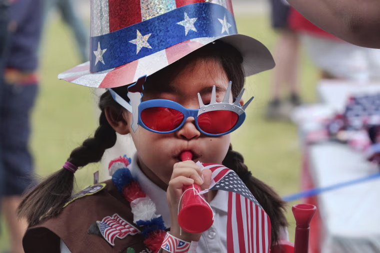 Image: Eight-year-old Hana Cho from Girl Scout Troop 5665 tests out a horn prior to participating the Fourth of July parade in Santa Monic