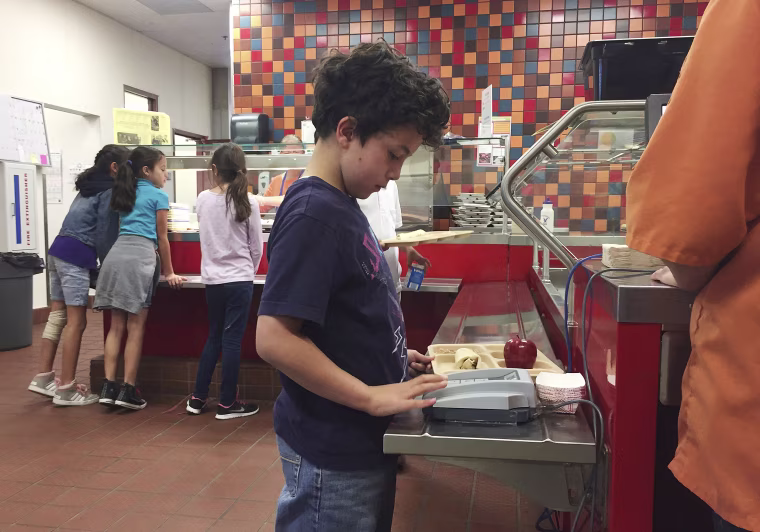 Image: third grade student Lucas Jameson taps in his student identification number to deduct a meal payment at Gonzales Community School