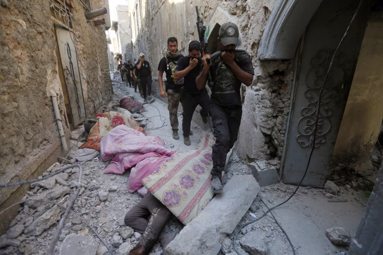 Image: Iraqi Counter Terrorism Service (CTS) personnel walk next to Islamic State militants' bodies in the Old City of Mosul