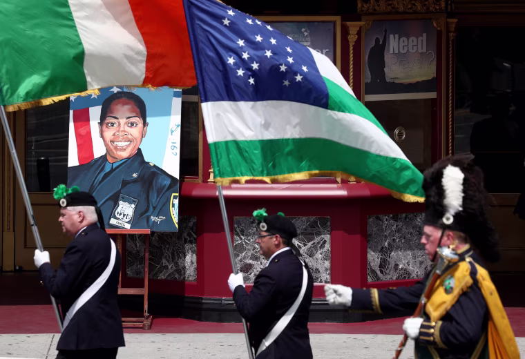 Image:  Flags are carried past a photo of slain New York Police Department Officer Miosotis Familia