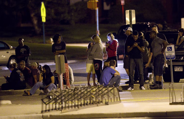 Image: Family and friends wait outside Gateway High School in Aurora