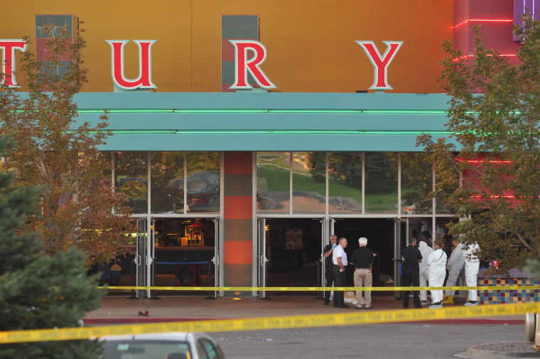 Image: Investigators work at the movie theater