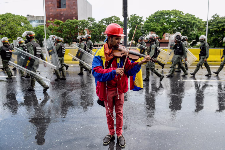 Image: An opposition demonstrator plays the violin during a protest against President Nicolas Maduro in Caracas, on May 24, 2017.