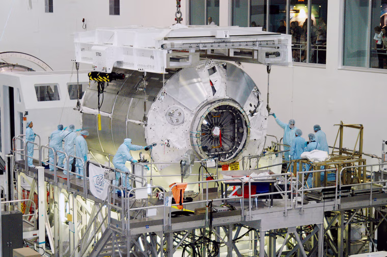 In the Space Station Processing Facility at NASA's Kennedy Space Center, workers help the Multi-Purpose Logistics Module Donatello settle onto a work stand in February 2004.