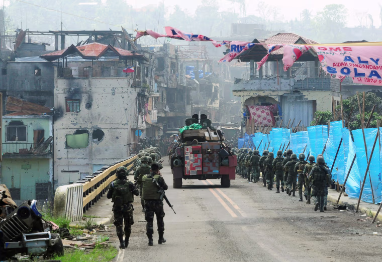 Image: Government troops march towards the Mapandi bridge during a battle against insurgents