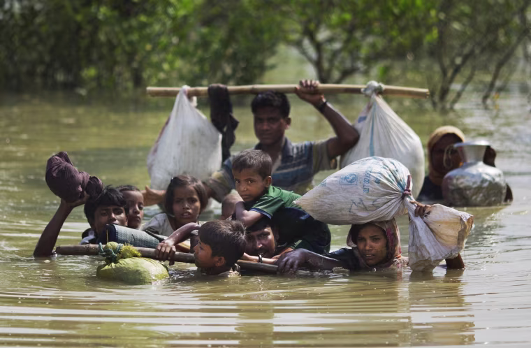 Image: A Rohingya family reaches the Bangladesh border after crossing a creek of the Naf river