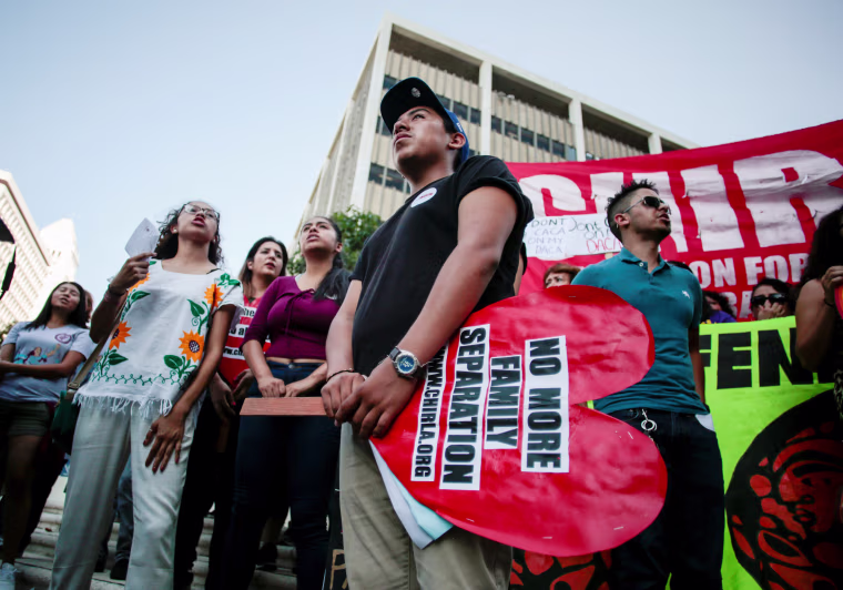 Image: Axel, 15, the son of a DACA program recipient, stands with supporters during a rally outside the Federal Building in Los Angeles