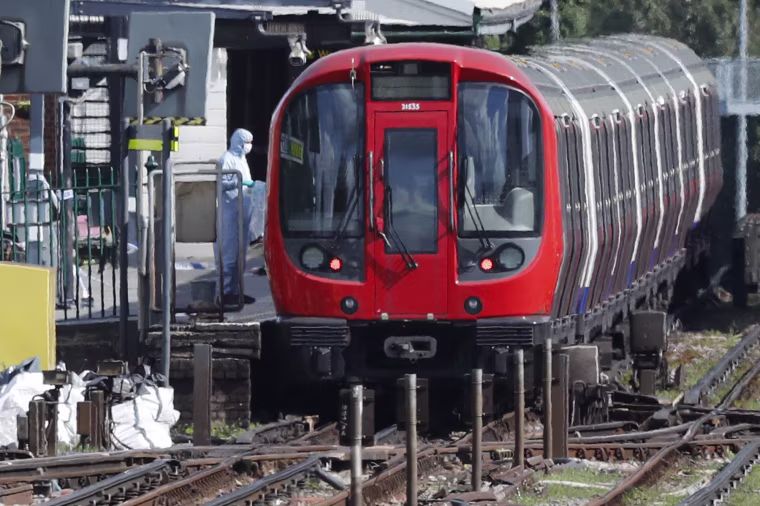 Image: A police forensic officer stands beside a train at Parsons Green subway station