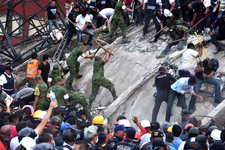 Image: Rescuers remove rubble from a building