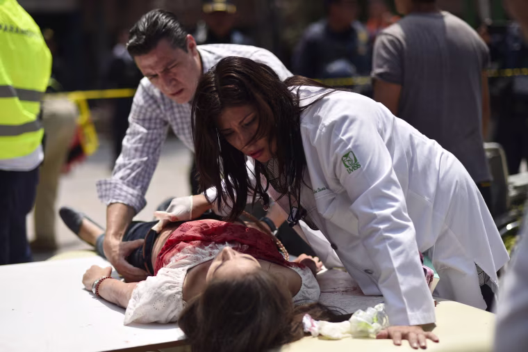 Image: An injured woman is treated after a powerful earthquake in Mexico City