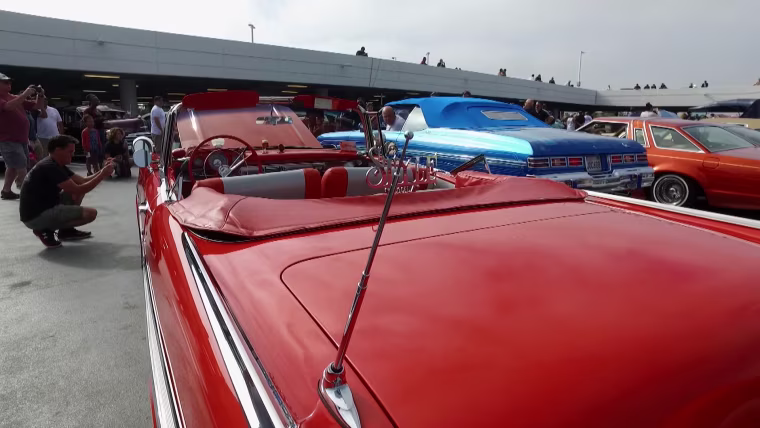 Lowrider owners display their cars at the "High Art of Riding Low: Ranflas, Corazon E Inspiracion" exhibit at the Petersen Automotive Museum in Los Angeles