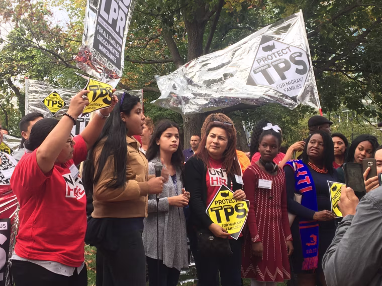 TPS holders march around DHS offices carrying posters and banners.