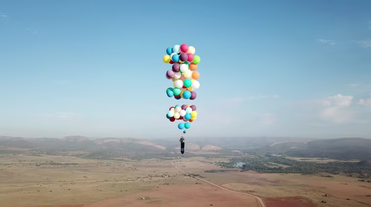 Image: Tom Morgan, from Bristol-based company The Adventurists, flies in a chair with large party balloons tied to it near Johannesburg, South Africa